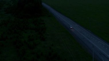 Gün batımının arka planında bir arabanın hava görüntüsü.