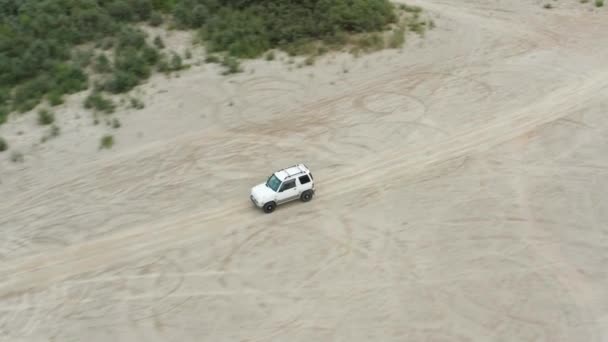 Vista aérea de un coche conduciendo sobre arena — Vídeo de stock