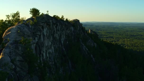 Vue aérienne d'une fille méditant sur un rocher au coucher du soleil — Video