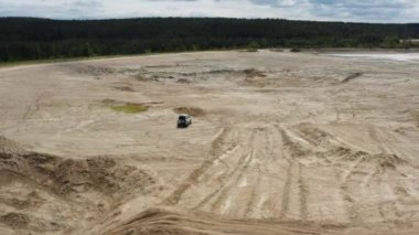 Kum üzerinde giden bir arabanın havadan görünüşü