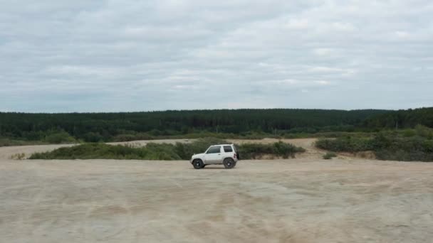 Вид с воздуха на автомобиль, движущийся по песку — стоковое видео
