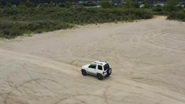 Vista aérea de un coche conduciendo sobre arena — Vídeos de Stock