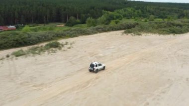 Kum üzerinde giden bir arabanın havadan görünüşü