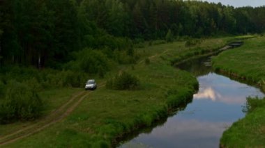 Nehir kıyısındaki bir arabanın hava görüntüsü.