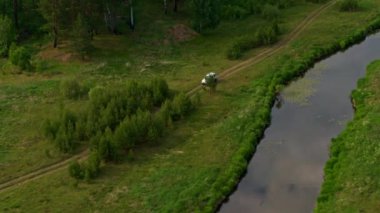 Nehir kıyısındaki bir arabanın hava görüntüsü.