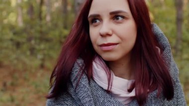Çekici bir kadının yakın portresi. Gülümseyen esmer, kendine güvenen güzel. Genç ve çekici bir kadın, rüyasında bir sonbahar ormanının arka planına bakıyor. Kendinden emin ve hayalperest bir kadın.