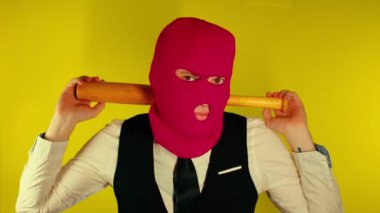 Beyzbol sopalı pembe kar maskeli adam. Elinde yarasa olan maskeli bir holigan. Elinde tahta bir sopayla şık bir takım elbise giyen bir adam.