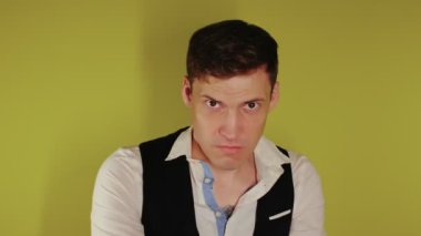 Katı yüzlü bir adam tahta sopayla poz veriyor. Elinde tahta bir sopayla şık takım elbiseli bir adam. Saldırgan iş.