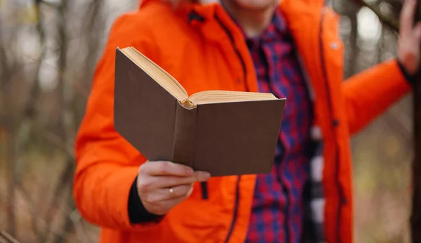 Közelről férfi kéz a könyvvel. Felismerhetetlen férfi tart könyv, álló erdő. — Stock Fotó