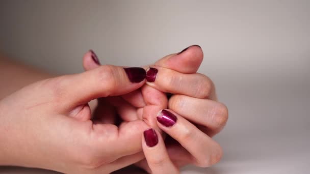 Nervös kvinna plockar på sina röda naglar. Närbild av kvinnor händer plocka hennes naglar. Kvinnliga remsor röda nagellack av naglarna med fingrarna från stress — Stockvideo