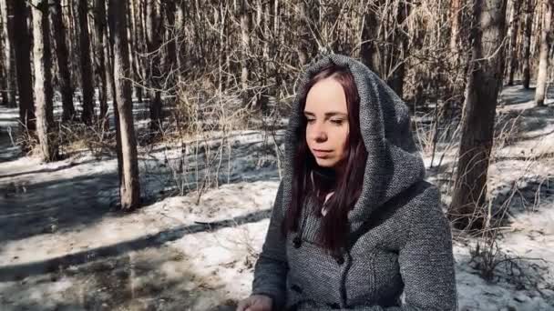 Młoda kobieta w szarym płaszczu fotografująca na starym aparacie fotograficznym w lesie. Ładna kobieta robi zdjęcia starym aparatem wczesną wiosną. — Wideo stockowe