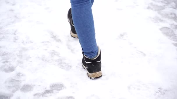 Una mujer camina en la nieve, de cerca. Invierno camina concepto — Vídeo de stock