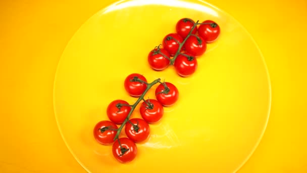 Tomates cherry orgánicos jugosos frescos y maduros en un plato amarillo. Tomates rojos cereza en fondo texturizado amarillo. verduras y alimentos saludables — Vídeos de Stock