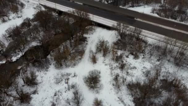 Trafiken en vinterdag. Bilar på väg på vintern med snötäckta träd flygfoto. — Stockvideo