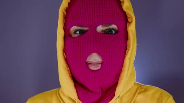 Porträtt av ung kvinna i rosa balaklava. Närbild av huligan i mask. — Stockfoto
