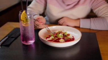 Masada krem peynirli sebzelerin leziz aperatifi. Tanınmayan kadın restoranda yemek yiyor. Kapat..