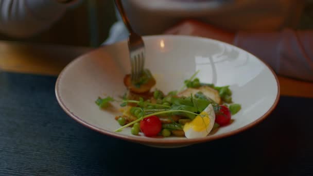 Salada apetitosa em prato branco. Mulher irreconhecível escolhe com garfo em prato. Fechar. — Vídeo de Stock