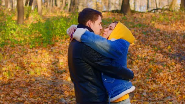 Šťastný pár objímající venku v podzimním lese. Muž a žena něžně objímající a líbající s láskou. — Stock video