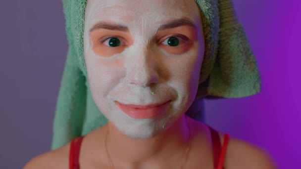 シャワー後は頭にタオルとマスクを被った若い女性。顔の化粧マスクで顔のレディーコート。国内の条件でスパ、スキンケア、自然の美しさの概念. — ストック動画