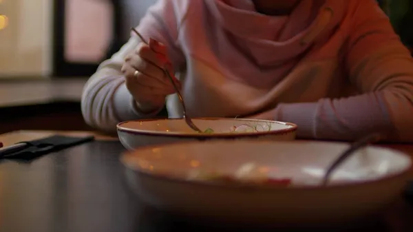 Appetithappen im Teller auf dem Tisch. Unerkennbare Frau isst Gericht im Restaurant. Nahaufnahme. — Stockfoto