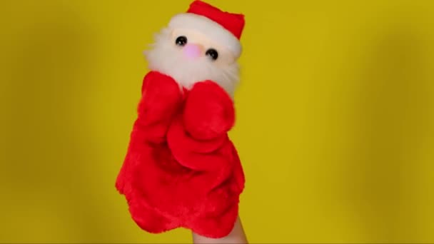 Soft puppet toy of santa claus on hand. Santa claus puppet on yellow background. Close up. Concept of puppet show and new year holidays. — Stock Video