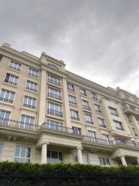 Şehir merkezinde bulutlu gökyüzüne karşı mimari bina cephesi. Modern evin dış binası