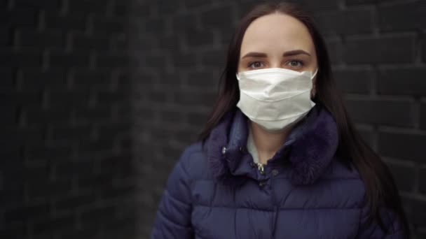 Egy Fiatal Arcképe Orvosi Maszkban Fekete Téglafalon Felnőtt Maszkkal Takarta — Stock videók