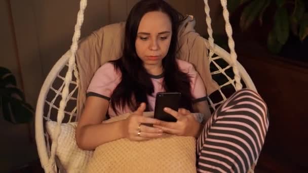 Hamakta Dinlenen Mutlu Genç Bir Kadın Akıllı Telefonuyla Evde Oturuyor — Stok video