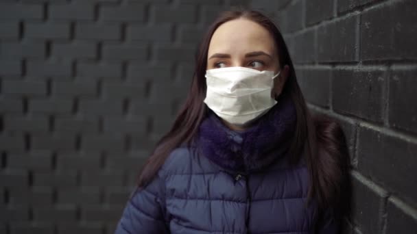 Potret Wanita Muda Bertopeng Medis Wajahnya Terhadap Dinding Bata Hitam — Stok Video