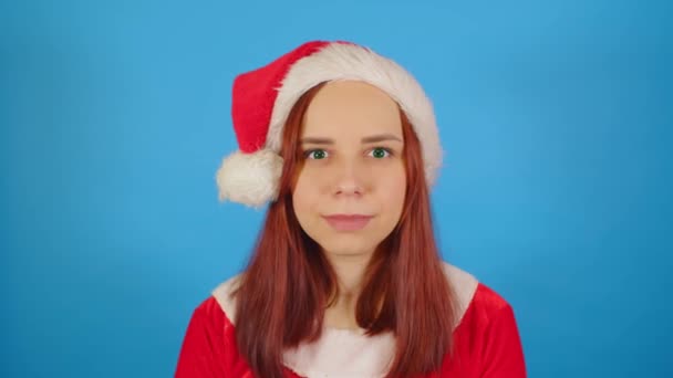Vrouw Kerstmankostuum Blauwe Achtergrond Vrouw Kerst Hoed Kijken Naar Camera — Stockvideo