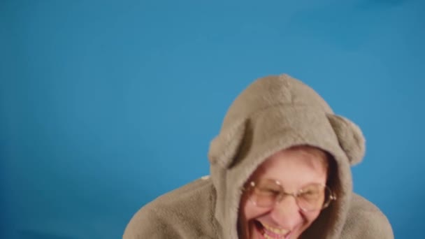 Άνθρωπος Γυαλιά Και Κουκούλα Αυτιά Γελώντας Μπλε Φόντο Χαρούμενος Τύπος — Αρχείο Βίντεο
