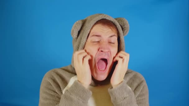 Man Hoodie Ears Scratches His Face Standing Blue Background Male — Stock Video
