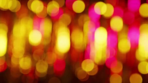 ピンクと黄色のライトはボケ効果があります。輝くガーランドの明るい光を墨色の斑点で表現した光沢のある抽象的な背景 — ストック動画
