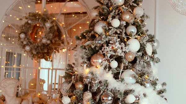 Árbol de Navidad con diferentes juguetes de Navidad y guirnalda brillante en la habitación. Árbol de coníferas decorado brillante con adornos para crear ambiente festivo durante las vacaciones. —  Fotos de Stock