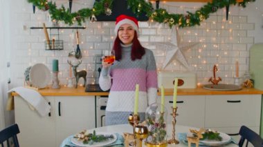 Noel Baba şapkalı genç kadınlar ellerinde kırmızı şarapla mutfakta mumlarla süslenmiş ve duvarda köknar dalları asılı bir şekilde akşam yemeği servisi yapıyorlardı.