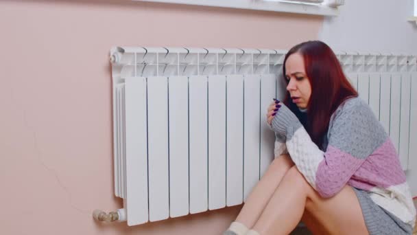Wanita menghangatkan tangan di radiator. Wanita puas dengan mata tertutup dan membuka mulut dengan sweater rajutan dan kaus kaki hangat tangan pada radiator pemanas pada hari musim dingin — Stok Video