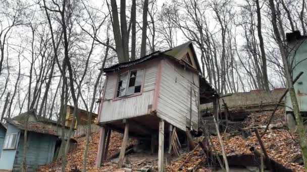 Antigua casa de madera destruida en utilería en el campo. Edificio exterior de casa rústica abandonada en la colina en el bosque. — Vídeos de Stock