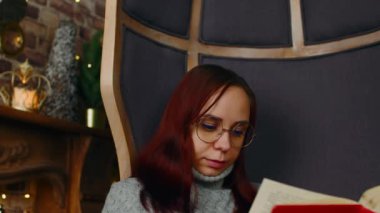 Gözlüklü genç kadın kitap okuyor. Gözlükle ilgilenen öğrenci kitap okuyor, eğitici derslere hazırlanıyor. Kapat..