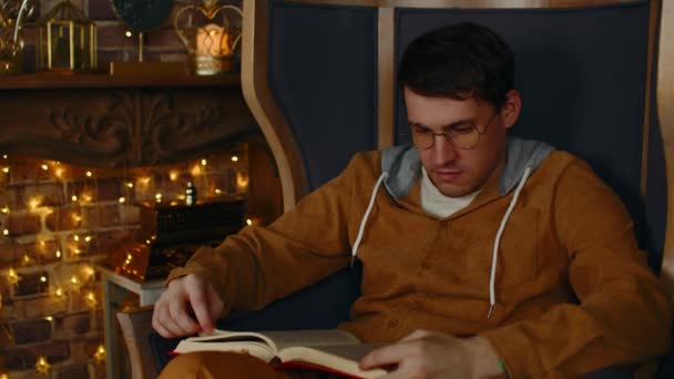 Young man in glasses reading book. Interested student in eyeglasses reads book, preparing for educational lessons — Video Stock