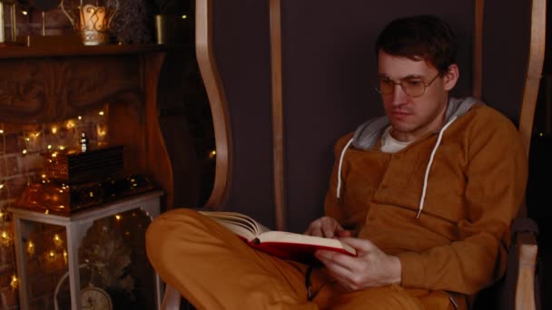 Young man in glasses reading book. Interested student in eyeglasses reads book, preparing for educational lessons — Video Stock