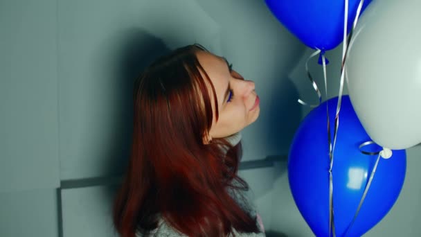 壁の近くに気球を持つ若い女性 笑顔の女性の肖像画部屋の風船の束を見て — ストック動画