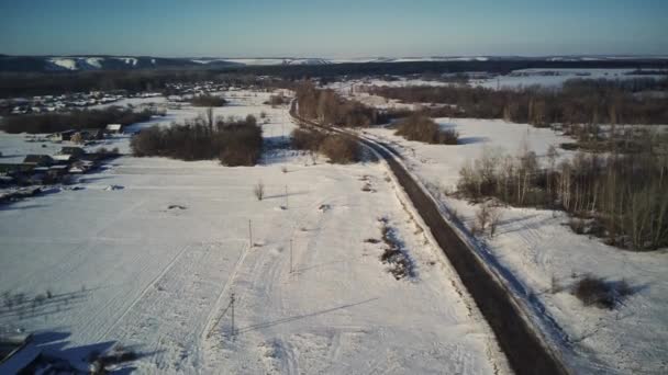 Vista Aérea Una Carretera Asfaltada Rodeada Nieve Campo Drone Vista — Vídeos de Stock