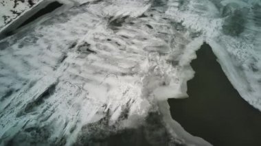 Kış mevsiminde buz dokusunun havadan görünüşü. Donmuş nehrin kuş bakışı görüntüsü. Buz gibi karlı nehir.