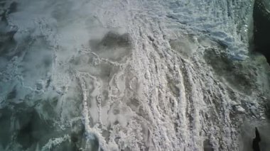 Kış mevsiminde buz dokusunun havadan görünüşü. Donmuş nehrin kuş bakışı görüntüsü. Buz gibi karlı nehir.