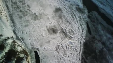 Kış mevsiminde buz dokusunun havadan görünüşü. Donmuş nehrin kuş bakışı görüntüsü. Buz gibi karlı nehir.