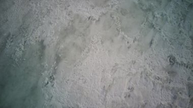 Kış mevsiminde buz dokusunun havadan görünüşü. Donmuş nehrin kuş bakışı görüntüsü. Buz gibi karlı nehir.