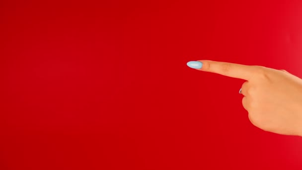 Las mujeres señalan el dedo índice en el espacio para el texto sobre fondo rojo. Persona irreconocible mostrando el gesto de señalar a su anuncio. — Vídeos de Stock
