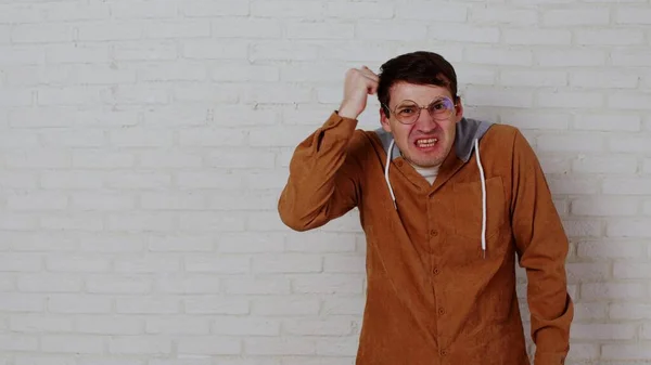 Mladý Emocionální Muž Brýlích Stojí Zdi Bílých Cihel Rozhořčený Samec — Stock fotografie