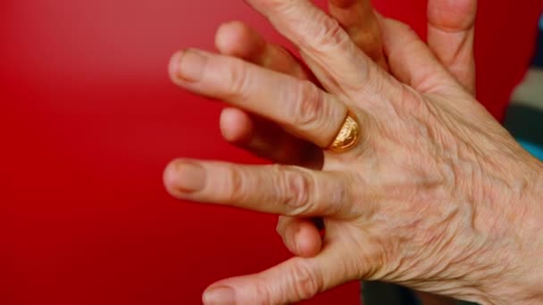 Mujeres mayores manos sobre fondo rojo. Mujer madura irreconocible mostrando gesto de dedos entrelazados. — Vídeo de stock