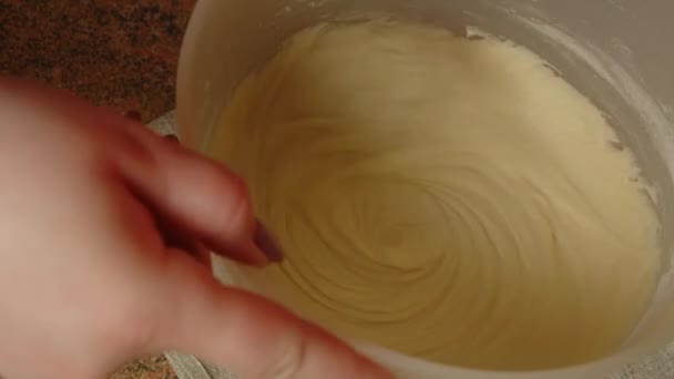 Felismerhetetlen személy habverővel keveri a tésztát a tálban. Ismeretlen háziasszony tésztát készít. Közelről. A házi sütéshez való tésztakészítés fogalma. — Stock videók